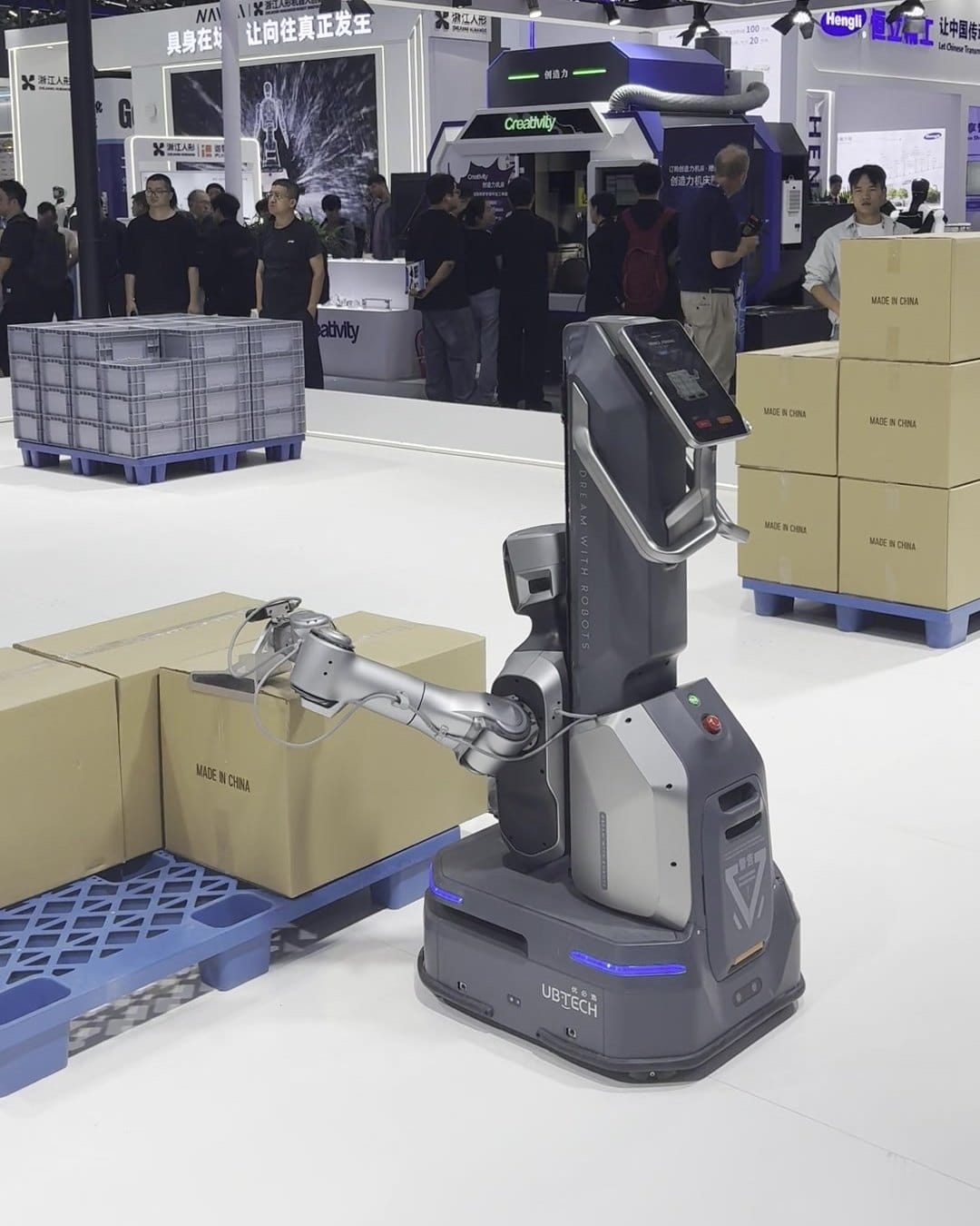 UBTECH wheeled robot with a gripper handling cardboard boxes next to a pallet at CIIF 2026